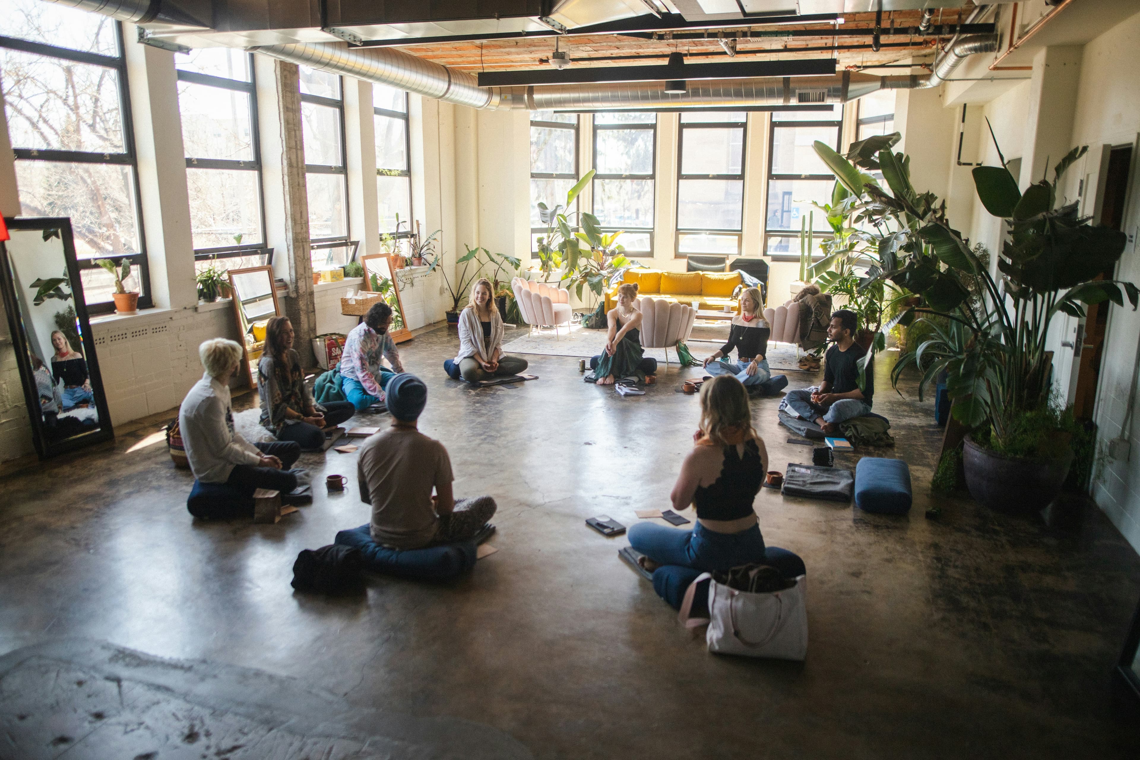 Group of women practicing yoga together outdoors in warrior pose